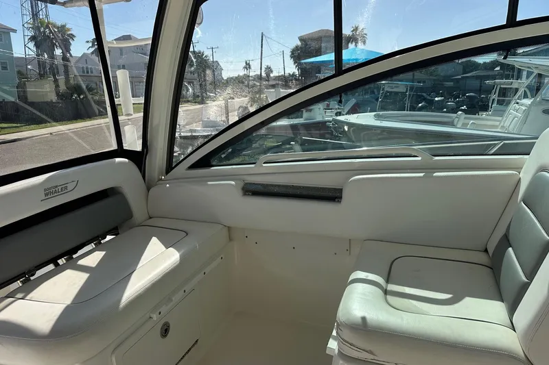 Slide: The Image of Interior view of a 2012 Boston Whaler 315 Conquest boat with seating and windows. - 5