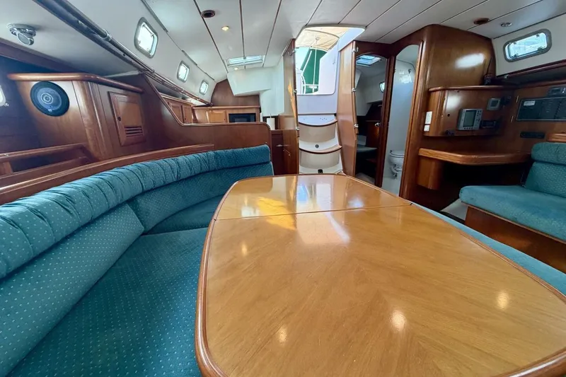 Slide: The Image of Luxurious interior of 2000 Beneteau Oceanis 461 sailboat with wood finish and seating area. - 10