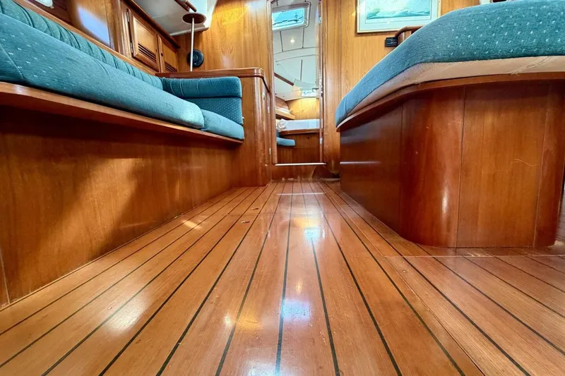 Slide: The Image of Interior of 2000 Beneteau Oceanis 461 yacht with polished wood flooring and blue seating. - 16