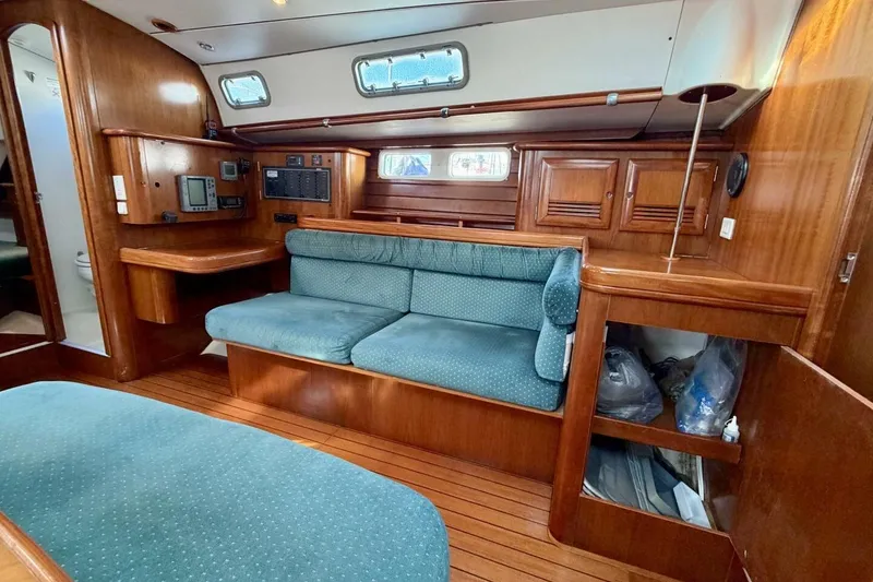 Slide: The Image of Interior of 2000 Beneteau Oceanis 461 sailboat with wood finish and green upholstery. - 17