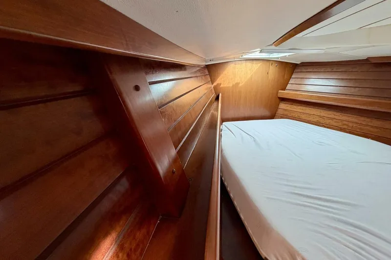 Slide: The Image of Interior cabin of 2000 Beneteau Oceanis 461 with wooden paneling and bed. - 21
