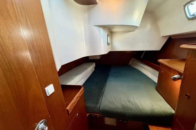 Slide: The Image of Interior cabin of 2000 Beneteau Oceanis 461 sailboat, featuring cozy wooden furnishings. - 27