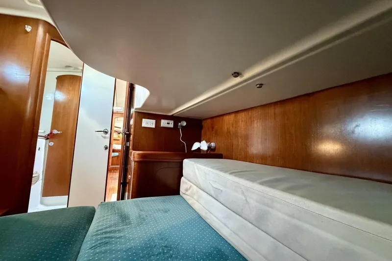 Slide: The Image of Interior cabin of 2000 Beneteau Oceanis 461 yacht with wooden finish and cozy bedding. - 30