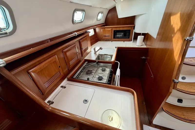 Slide: The Image of Interior of 2000 Beneteau Oceanis 461 yacht kitchen with wood cabinetry and appliances. - 36