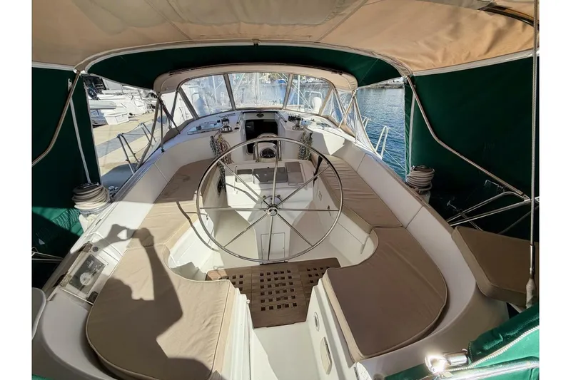 Slide: The Image of Spacious cockpit of 2000 Beneteau Oceanis 461 sailboat with cushioned seating and steering wheel. - 48