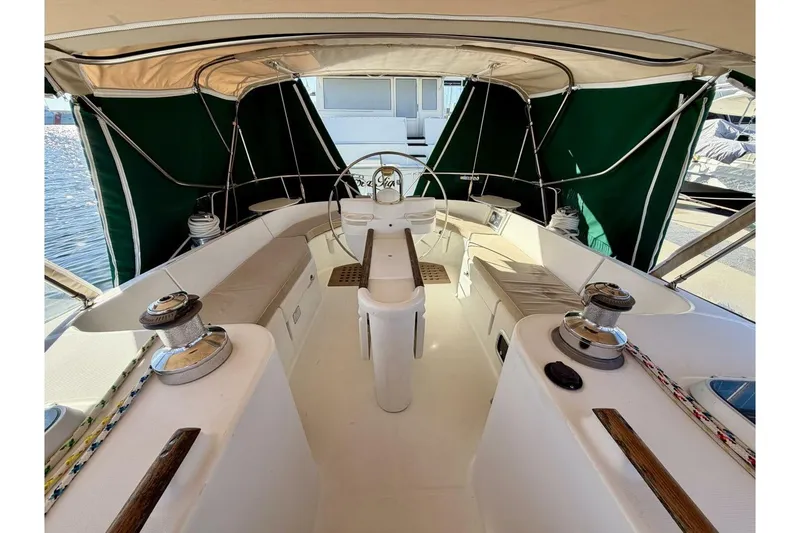 Slide: The Image of Cockpit of 2000 Beneteau Oceanis 461 sailboat with green canopy and steering wheel. - 54