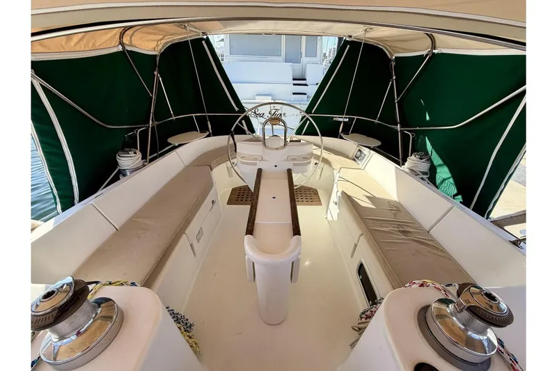 Slide: The Image of 2000 Beneteau Oceanis 461 yacht cockpit with green canopy and seating area. - 55