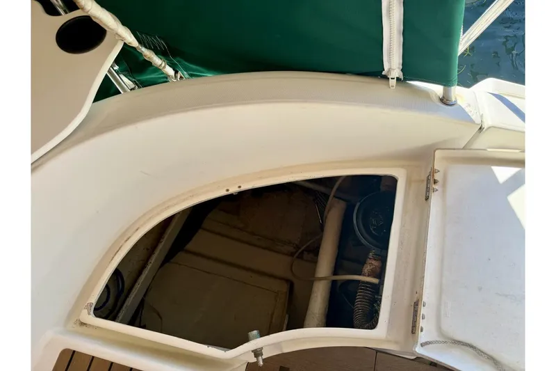 Slide: The Image of Beneteau Oceanis 461 (2000) cockpit storage compartment with open hatch and green cover. - 57