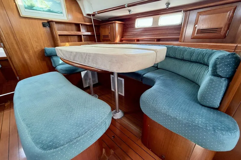 Slide: The Image of Interior of 2000 Beneteau Oceanis 461 yacht with blue upholstered seating and wooden finishes. - 8