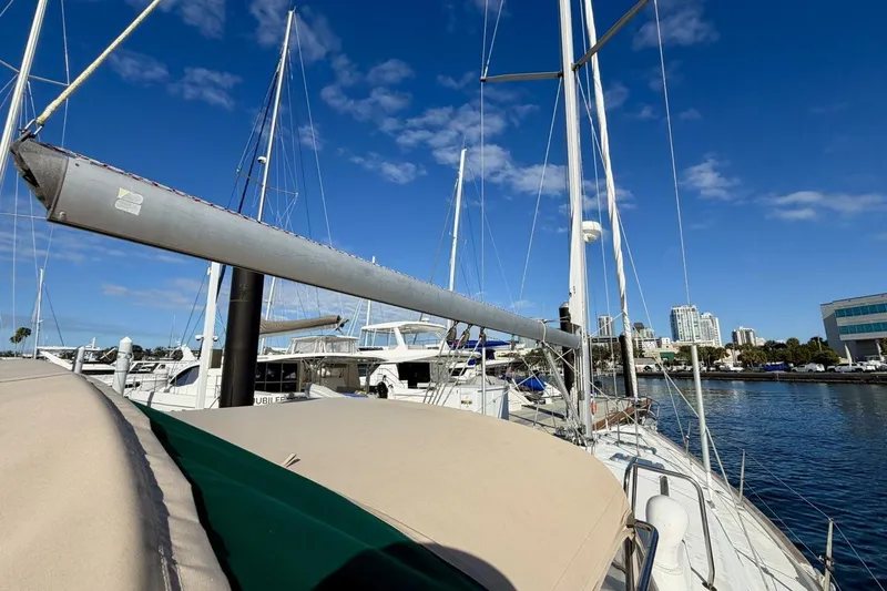 Slide: The Image of Beneteau Oceanis 461 sailboat docked at marina, clear blue sky, cityscape background. - 81