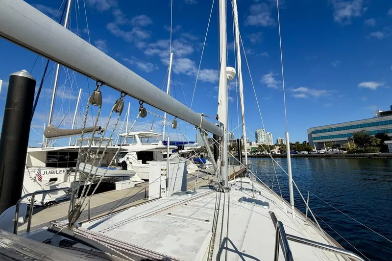 Slide: The Image of Beneteau Oceanis 461 sailboat docked at marina, clear blue sky, cityscape background. - 83
