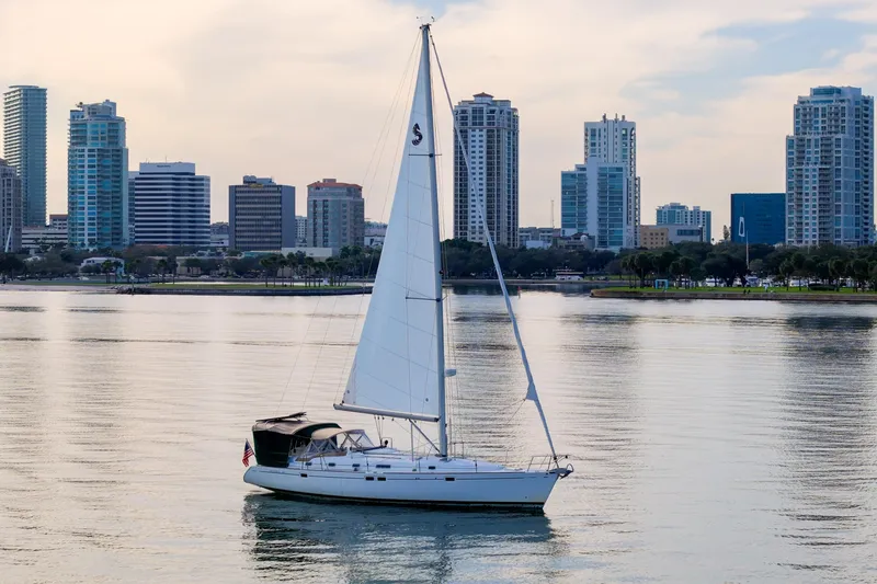 Slide: The Image of Sailboat Beneteau Oceanis 461 (2000) on calm water with city skyline backdrop. - 94