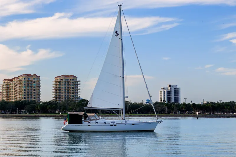 Slide: The Image of Sailboat Beneteau Oceanis 461 (2000) on calm water with cityscape background. - 95