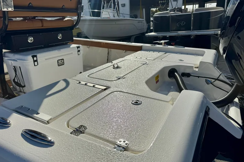 Slide: The Image of 2026 Key West 230 Bay Reef boat interior with storage compartments and cooler. - 13