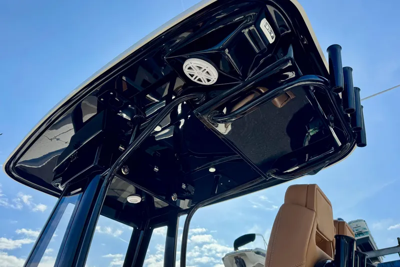 Slide: The Image of 2026 Key West 230 Bay Reef boat's sleek black T-top against a clear blue sky. - 16