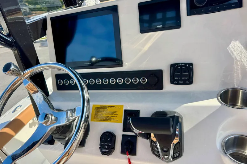 Slide: The Image of 2026 Key West 230 Bay Reef boat dashboard with steering wheel and electronic controls. - 24