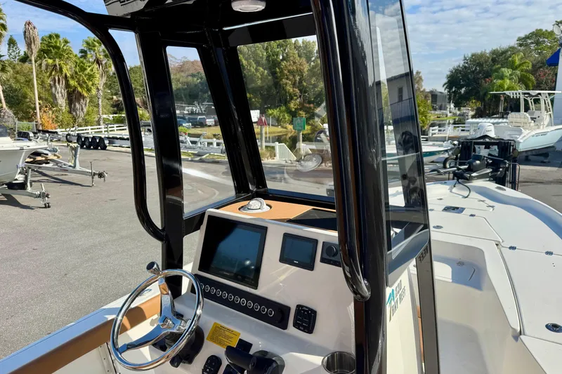Slide: The Image of 2026 Key West 230 Bay Reef boat dashboard with steering wheel and navigation display. - 25