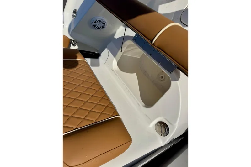 Slide: The Image of 2026 Key West 230 Bay Reef boat interior with brown quilted seating and speaker. - 30