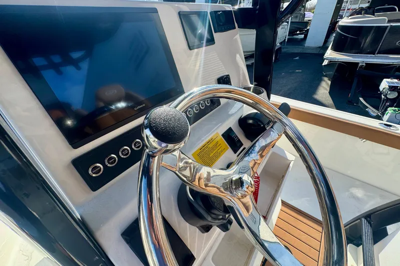 Slide: The Image of 2026 Key West 230 Bay Reef boat dashboard with steering wheel and navigation display. - 37