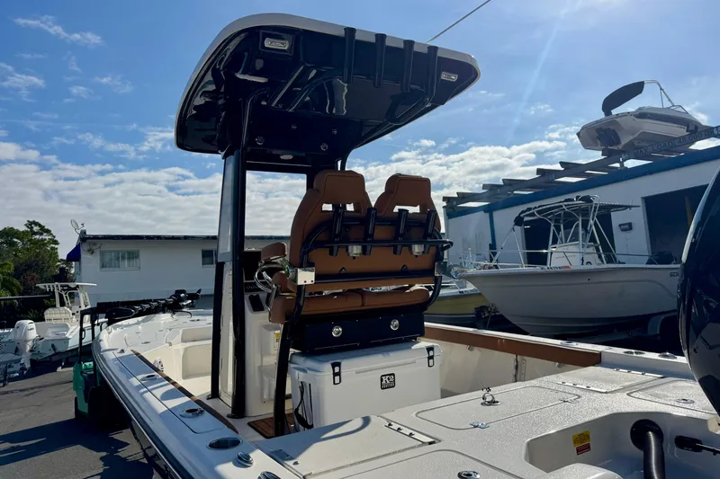 Slide: The Image of 2026 Key West 230 Bay Reef boat with T-top and dual seats, docked under a clear sky. - 39
