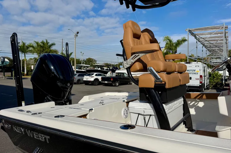 Slide: The Image of 2026 Key West 230 Bay Reef boat with tan seats and black motor in a sunny marina. - 8