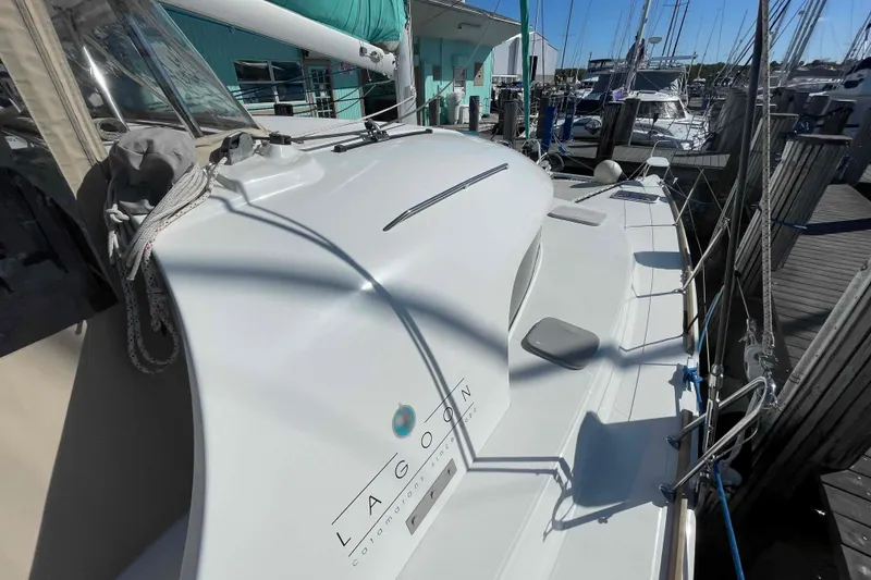 Slide: The Image of Lagoon 380 S2 catamaran, 2012 model, docked at a marina under clear blue skies. - 100