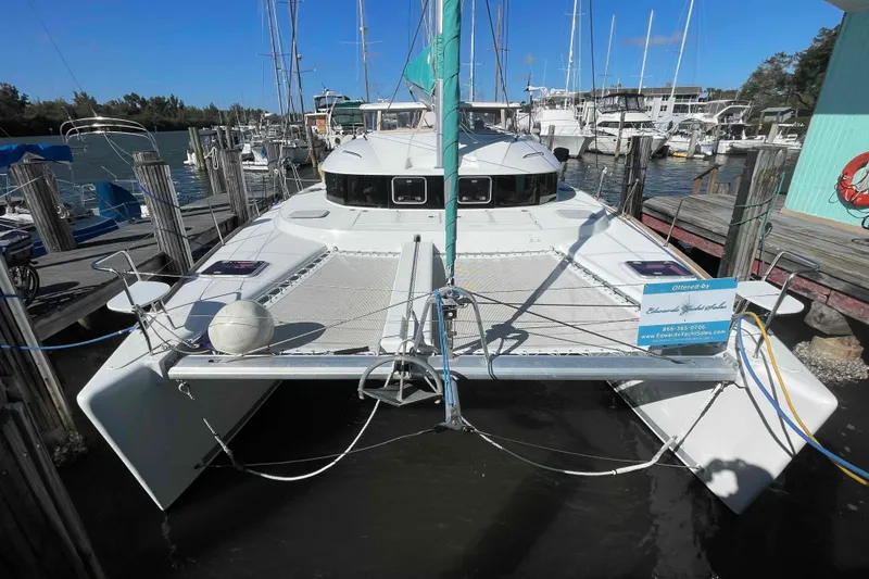 Slide: The Image of 2012 Lagoon 380 S2 catamaran docked at a marina, front view. - 105