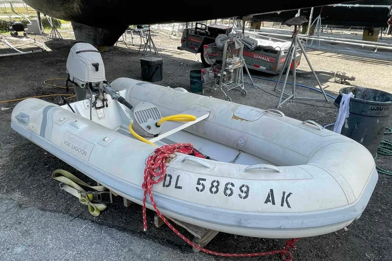 Slide: The Image of 2012 Lagoon 380 S2 catamaran docked at marina under cloudy sky. - 25