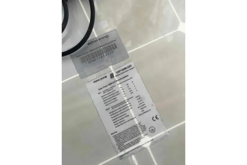 Slide: The Image of Side view of a 2012 Lagoon 380 S2 catamaran against a clear blue sky. - 56