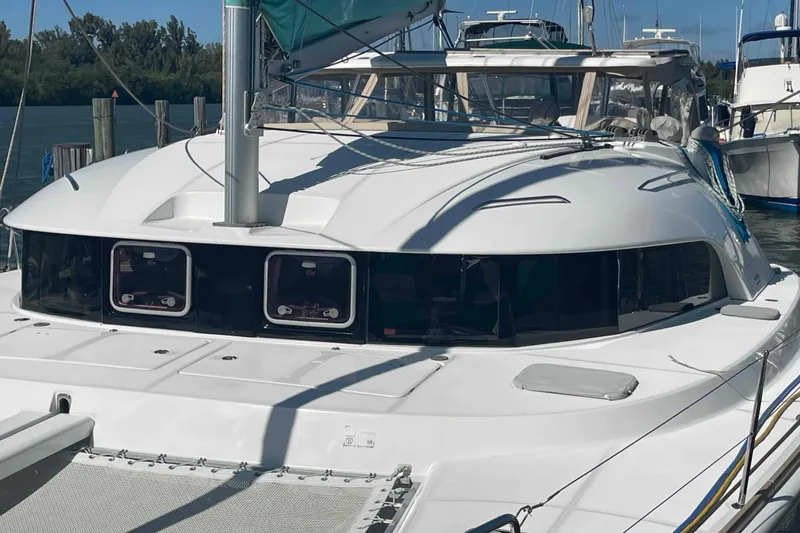 Slide: The Image of 2012 Lagoon 380 S2 catamaran docked at marina, featuring sleek design and spacious deck. - 96