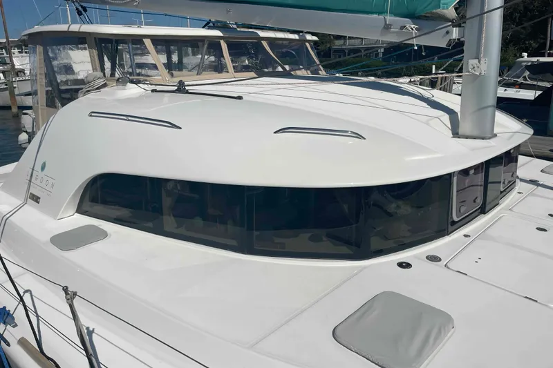 Slide: The Image of 2012 Lagoon 380 S2 catamaran docked, showcasing sleek design and spacious windows. - 97