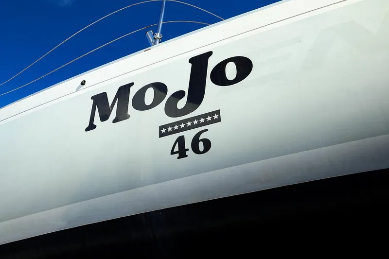Slide: The Image of 2004 J Boats J/46 sailboat named "MoJo" with star design on hull. - 2