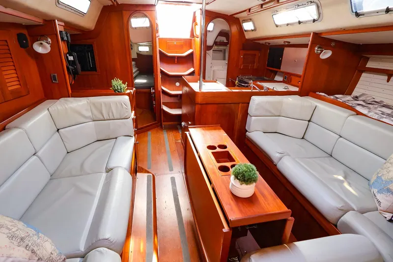 Slide: The Image of 2004 J Boats J/46 interior with plush seating, wooden finishes, and natural light. - 23