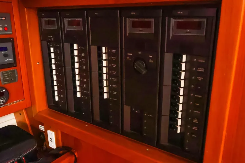 Slide: The Image of Electrical panel on a 2004 J Boats J/46 yacht, featuring multiple switches and controls. - 32