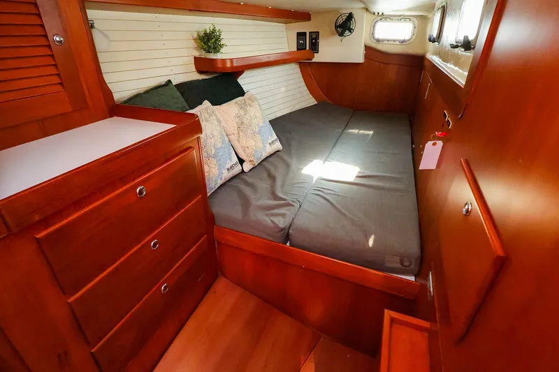 Slide: The Image of 2004 J Boats J/46 cabin interior with wooden furnishings and cozy bedding. - 39