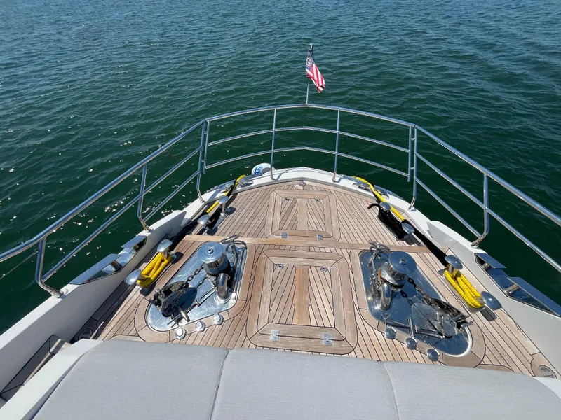 Slide: The Image of Azimut Grande 27M 2019 yacht deck with railing and American flag on calm water. - 16