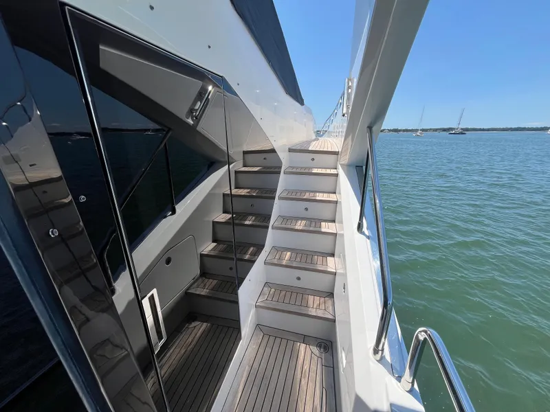 Slide: The Image of 2019 Azimut Grande 27M yacht deck with wooden stairs and ocean view. - 27