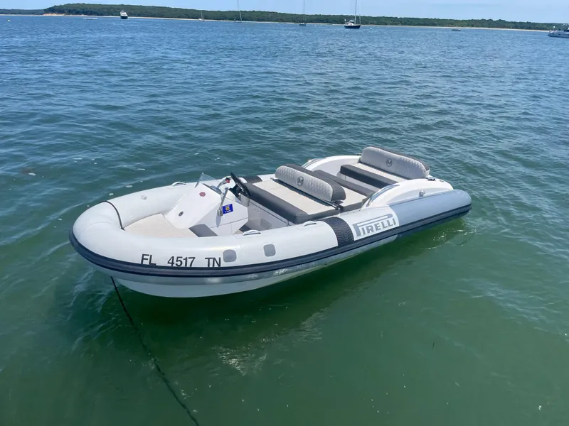 Slide: The Image of Inflatable boat on water, featuring Pirelli branding, near Azimut Grande 27M yacht. - 7