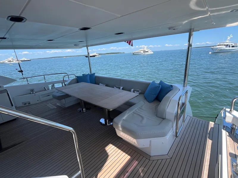 Slide: The Image of Luxury Azimut Grande 27M yacht deck with seating, table, and ocean view, 2019 model. - 9