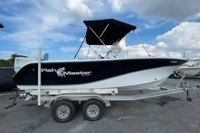 Slide: The Image of 2004 Kenner Fishmaster Travis Edition 220 boat interior with steering console and seating. - 12