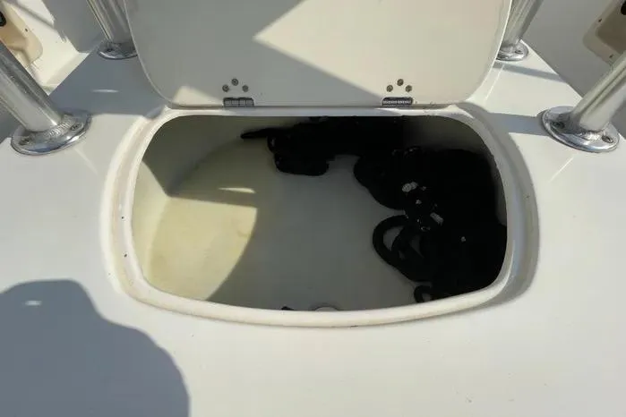 Slide: The Image of 2004 Kenner Fishmaster Travis Edition 220 boat with canopy and steering console, docked outdoors. - 18