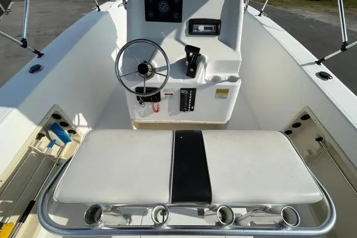 Slide: The Image of 2004 Kenner Fishmaster Travis Edition 220 boat interior with steering wheel and controls. - 21