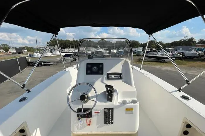 Slide: The Image of 2004 Kenner Fishmaster Travis Edition 220 boat console with steering wheel and gauges. - 23