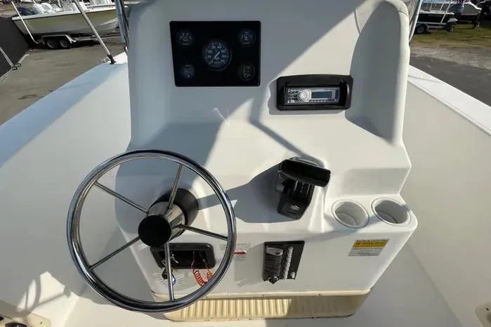 Slide: The Image of 2004 Kenner Fishmaster Travis Edition 220 boat console with steering wheel and controls. - 24