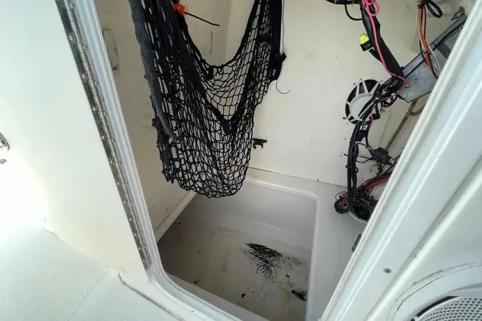 Slide: The Image of 2004 Kenner Fishmaster Travis Edition 220 boat interior with white seating and storage. - 33