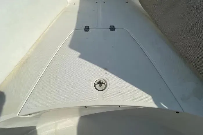 Slide: The Image of 2004 Kenner Fishmaster Travis Edition 220 boat interior, featuring white seating and storage compartment. - 39