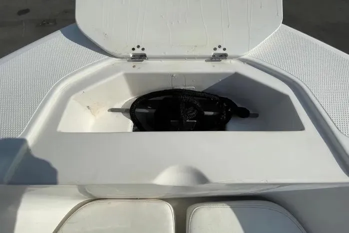 Slide: The Image of 2004 Kenner Fishmaster Travis Edition 220 boat with seating and canopy, parked on pavement. - 42