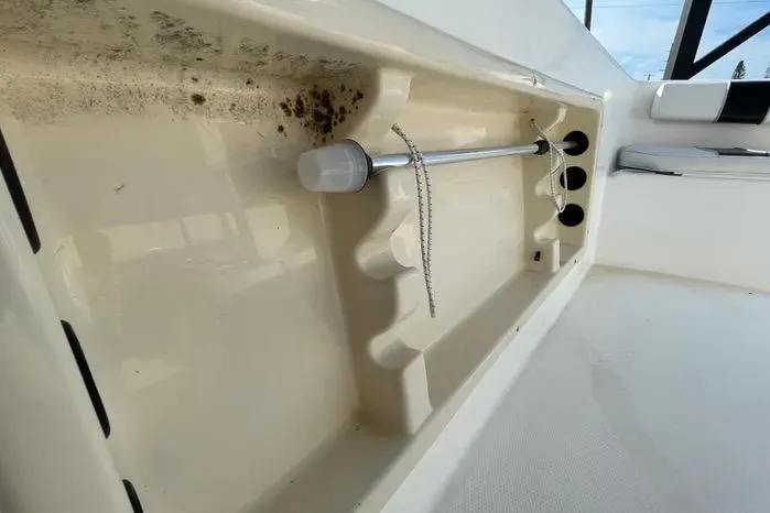 Slide: The Image of 2004 Kenner Fishmaster Travis Edition 220 boat interior with seating and rod holders. - 52