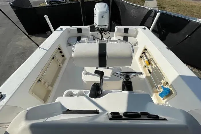 Slide: The Image of 2004 Kenner Fishmaster Travis Edition 220 boat interior with seating and Suzuki outboard motor. - 53