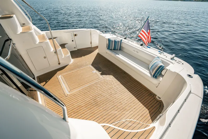 Slide: The Image of 2007 Sea Ray 580 Sedan Bridge yacht deck with seating, American flag, and ocean view. - 10